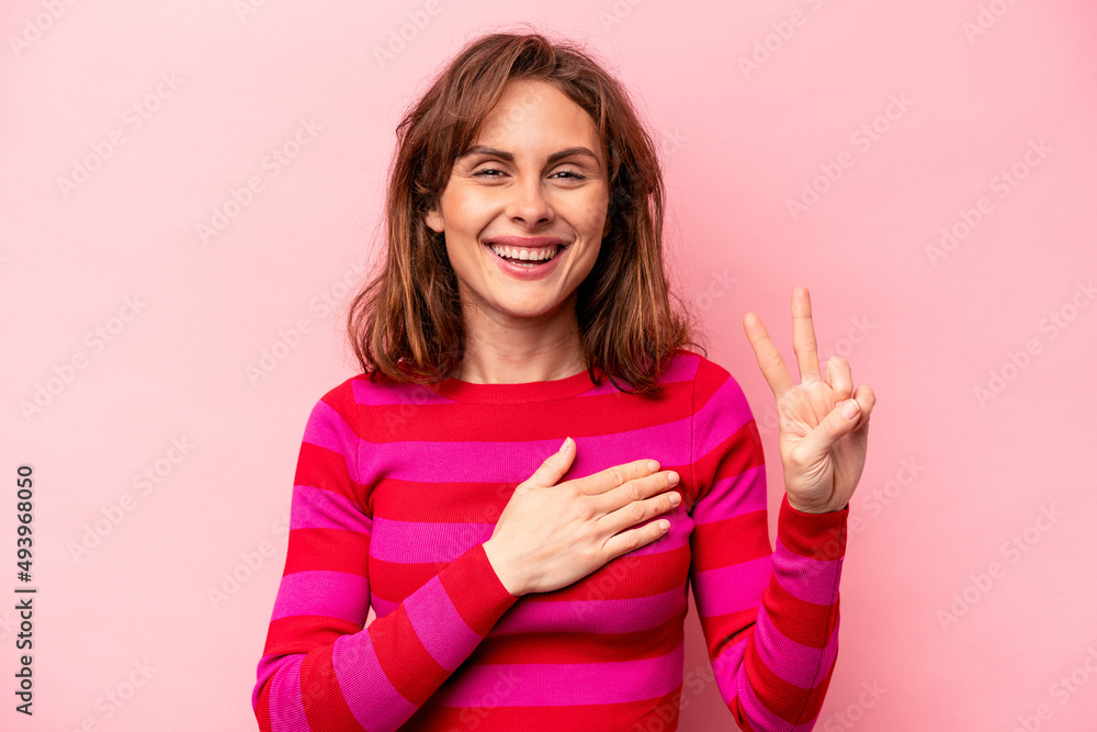 Young caucasian woman isolated on pink background taking an oath, putting hand on chest. Young caucasian woman isolated on pink background taking an oath, putting hand on chest.