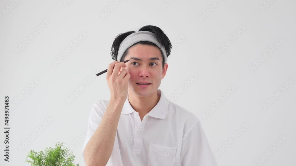眉毛を描く男性