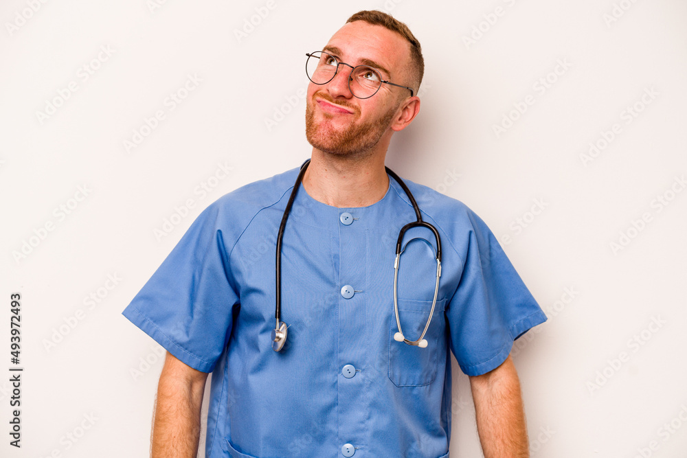 Young caucasian nurse man isolated on white background dreaming of achieving goals and purposes Young caucasian nurse man isolated on white background dreaming of achieving goals and purposes