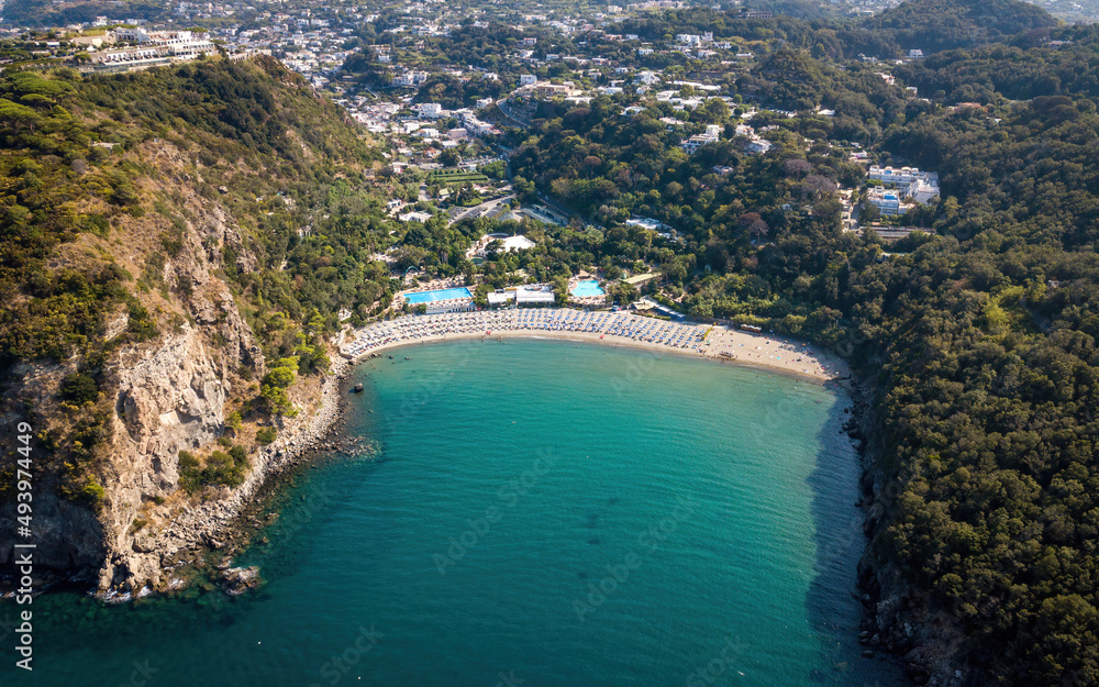 Sandy beach in a bay surrounded by hills (aerial drone photo). Ischia island, Italy