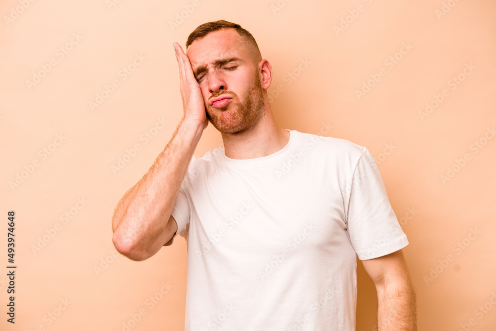 Young caucasian man isolated on beige background tired and very sleepy keeping hand on head. Young caucasian man isolated on beige background tired and very sleepy keeping hand on head.