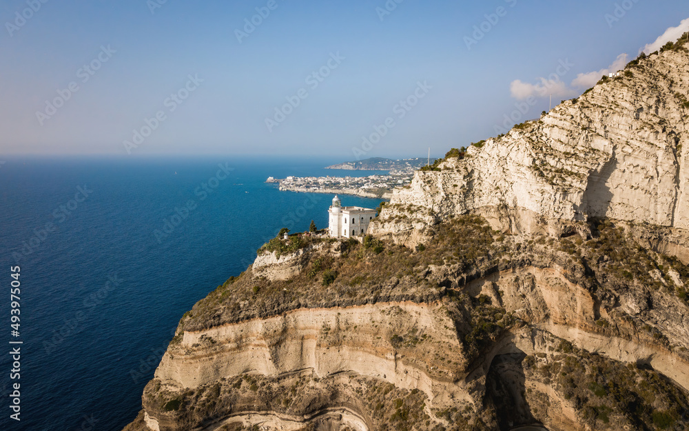 White lighthouse on a seaside cliff (aerial drone photo). Mediterranean, Ischia island, Italy