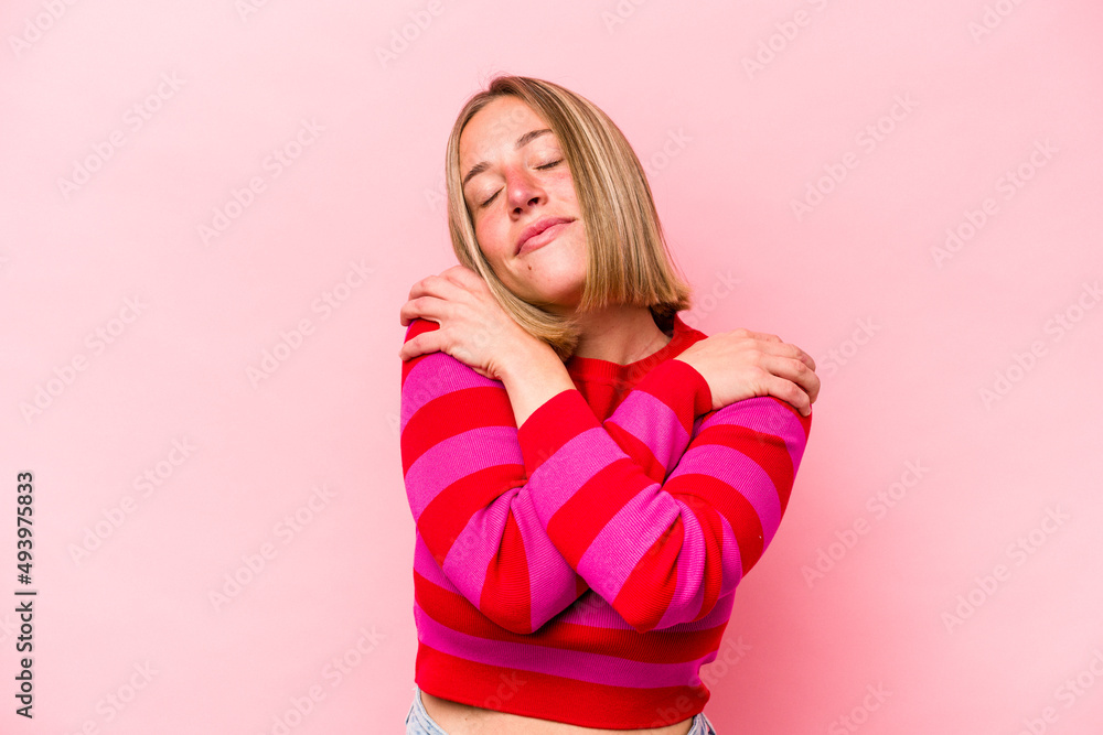 Young caucasian woman isolated on pink background hugs, smiling carefree and happy. Young caucasian woman isolated on pink background hugs, smiling carefree and happy.