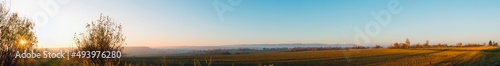 Panorama of plowed field on a background of the sun