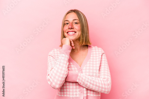Young caucasian woman isolated on pink background smiling happy and confident, touching chin with hand.