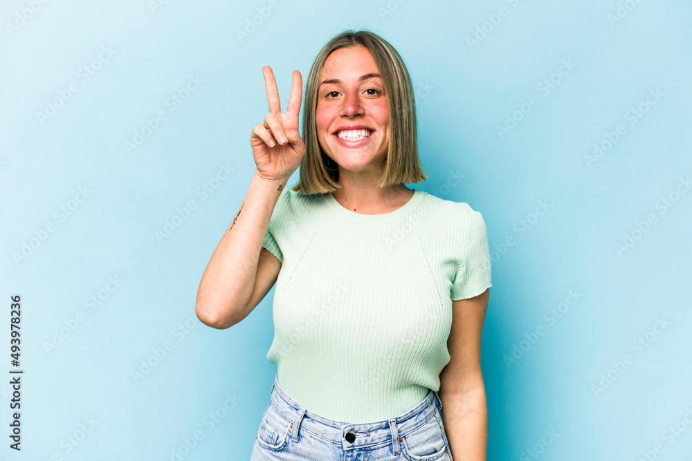 Young caucasian woman isolated on blue background showing number two with fingers. Young caucasian woman isolated on blue background showing number two with fingers.