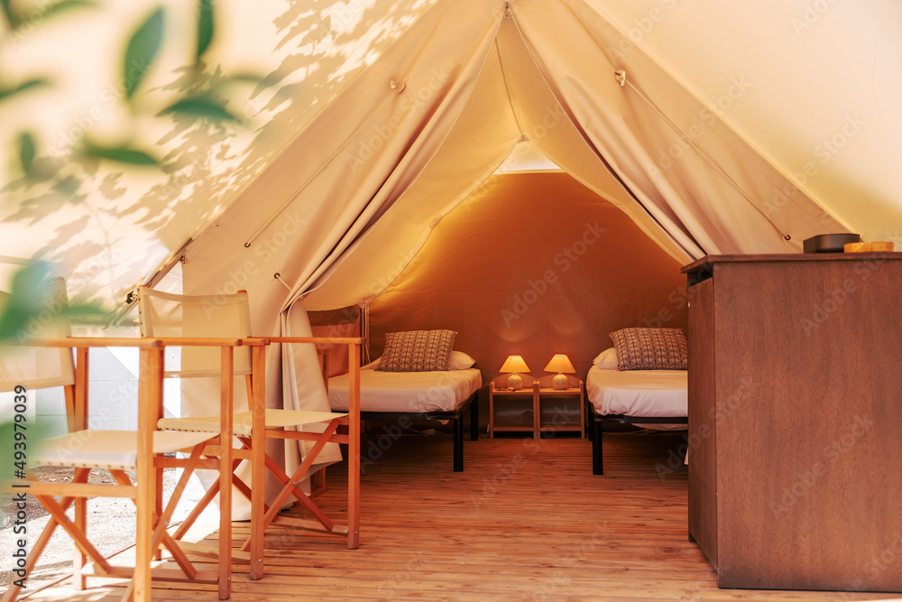 Glamping tent with cozy interior on a sunny day. Luxury camping tent for  outdoor summer holiday and vacation lifestyle concept Photos | Adobe Stock