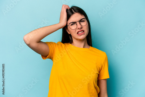 Young caucasian woman isolated on blue background tired and very sleepy keeping hand on head.