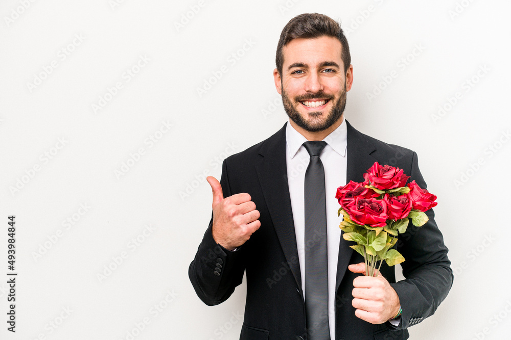 Young caucasian man holding a bouquet of flowers isolated on white background smiling and raising thumb up Young caucasian man holding a bouquet of flowers isolated on white background smiling and raising thumb up