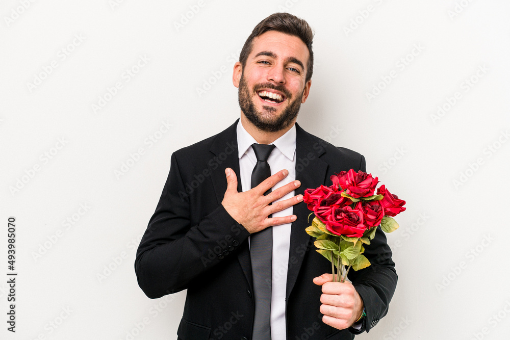 Young caucasian man holding a bouquet of flowers isolated on white background laughs out loudly keeping hand on chest. Young caucasian man holding a bouquet of flowers isolated on white background laughs out loudly keeping hand on chest.