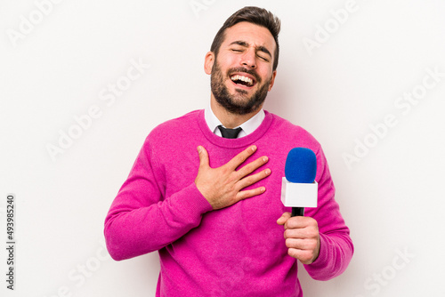 Young caucasian tv presenter man isolated on white background laughs out loudly keeping hand on chest.