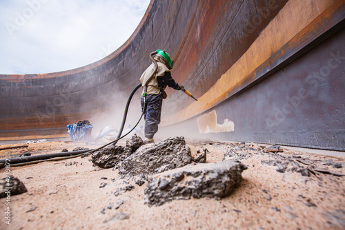 Slika na platnu Female worker surface corrosion plate preparation by sand blasting