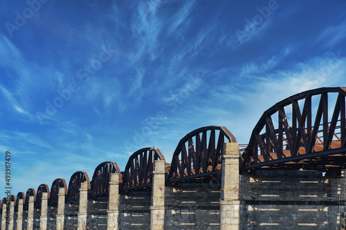 old rusty steel railway bridge with arches photo