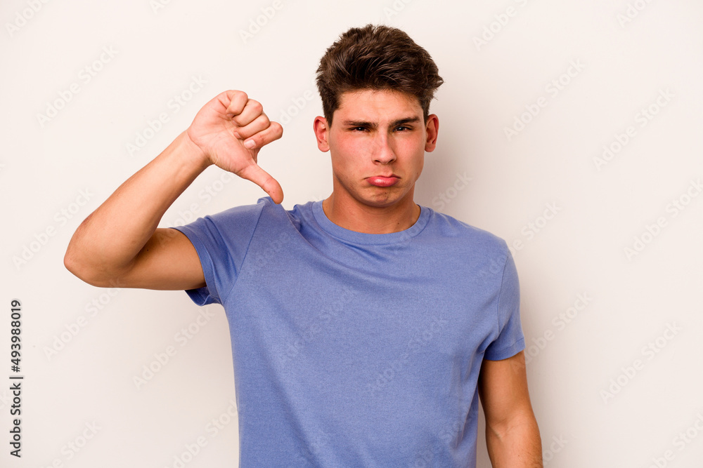 Young caucasian man isolated on white background showing a dislike gesture, thumbs down. Disagreement concept.