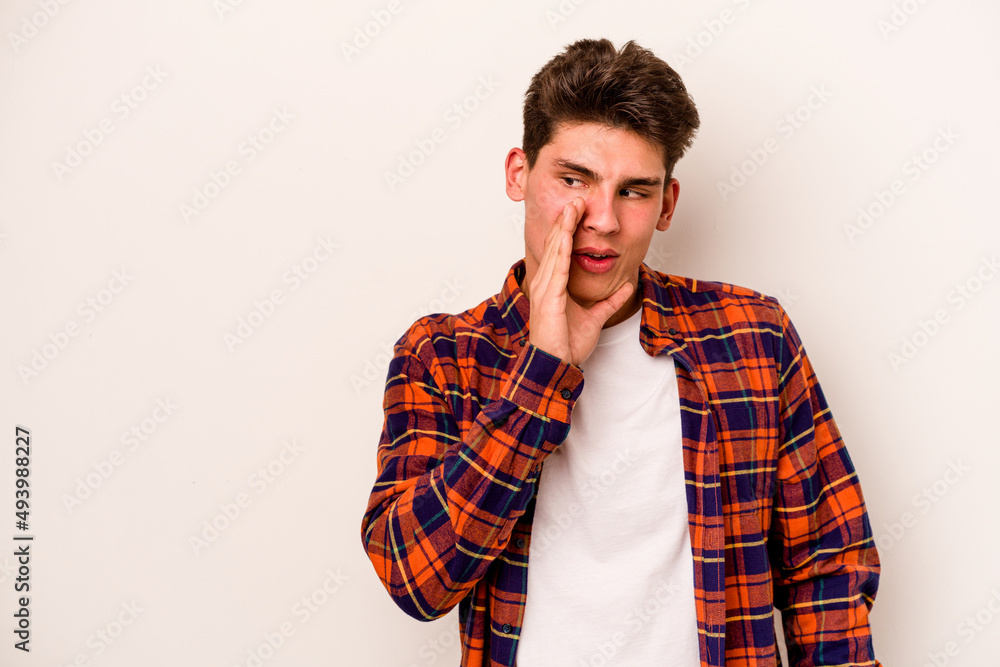 Young caucasian man isolated on white background is saying a secret hot braking news and looking aside Young caucasian man isolated on white background is saying a secret hot braking news and looking aside