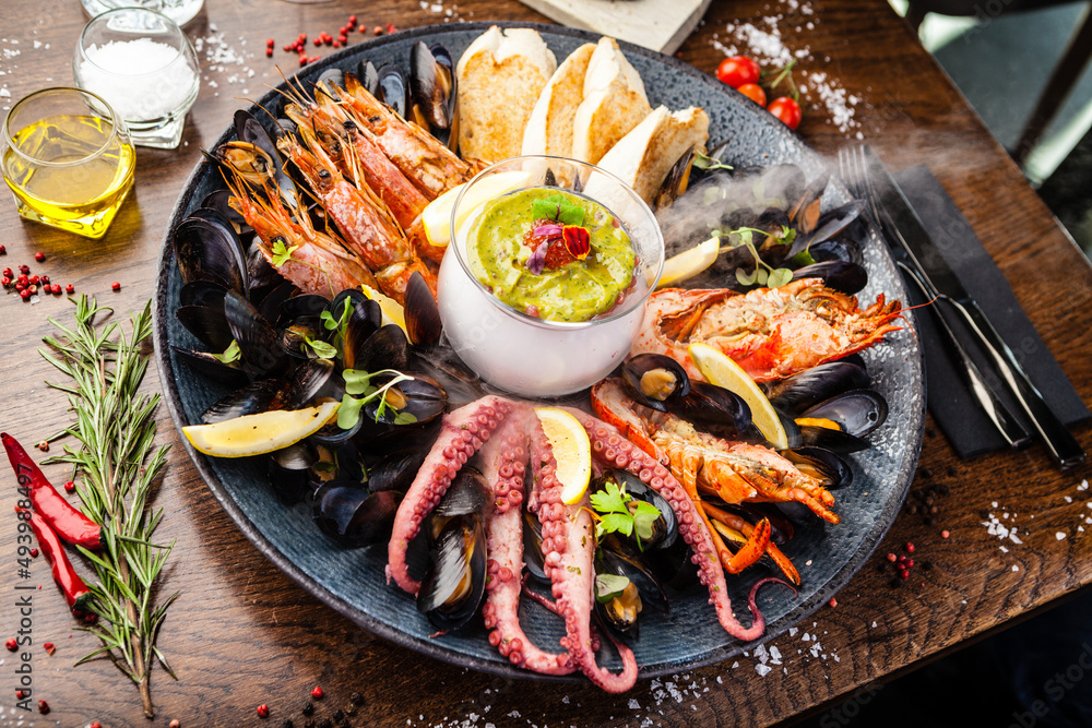 Seafood platter for 2-4 persons. Lobster, octopus, blue mussels, Argentina king prawns, tuna tartare. Delicious healthy traditional food closeup served for lunch in modern gourmet cuisine restaurant Seafood platter for 2-4 persons. Lobster, octopus, blue mussels, Argentina king prawns, tuna tartare. Delicious healthy traditional food closeup served for lunch in modern gourmet cuisine restaurant