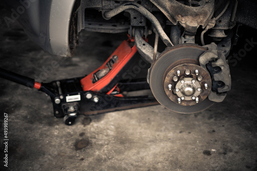 Car front axle, Car jack while being repaired, Car rebonding, Car being repaired, Car garage, Car brakes