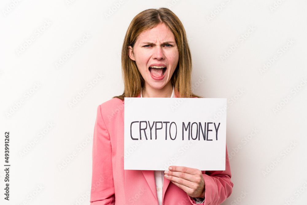 Young English business woman holding a crypto money placard isolated on white background screaming very angry and aggressive. Young English business woman holding a crypto money placard isolated on white background screaming very angry and aggressive.