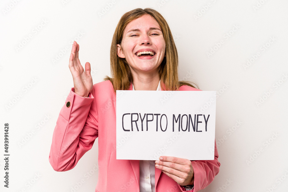 Young English business woman holding a crypto money placard isolated on white background receiving a pleasant surprise, excited and raising hands. Young English business woman holding a crypto money placard isolated on white background receiving a pleasant surprise, excited and raising hands.