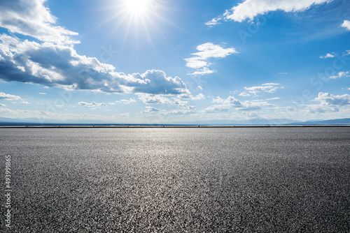 Asphalt road and sky clouds with sun landscape © ABCDstock