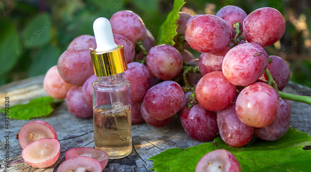 Grape seed oil in a glass jar and fresh grapes for spa and body care. The concept of spa, bio, eco products. Grape seed oil in a glass jar and fresh grapes for spa and body care. The concept of spa, bio, eco products.