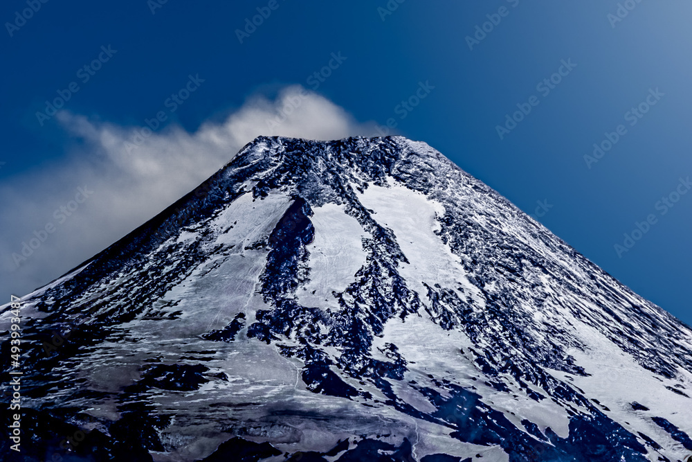 Fuming volcano covered in snow