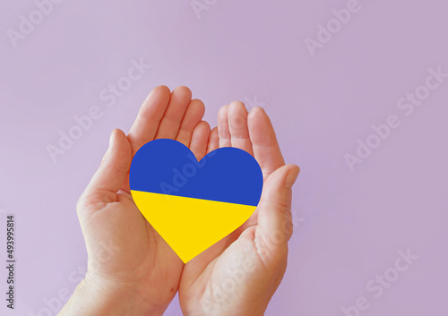 love blue and yellow heart in hands on colorful background. Ukraine concept 