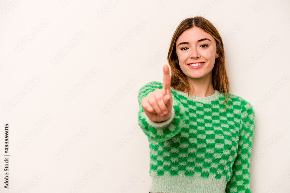 Young caucasian woman isolated on white background showing number one with finger. Young caucasian woman isolated on white background showing number one with finger.