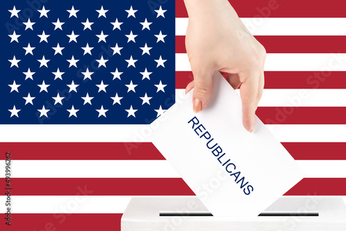 voting in the usa, a hand with a ballot for the republicans against the background of the american flag puts the vote in the ballot box, congressional elections, the senate photo