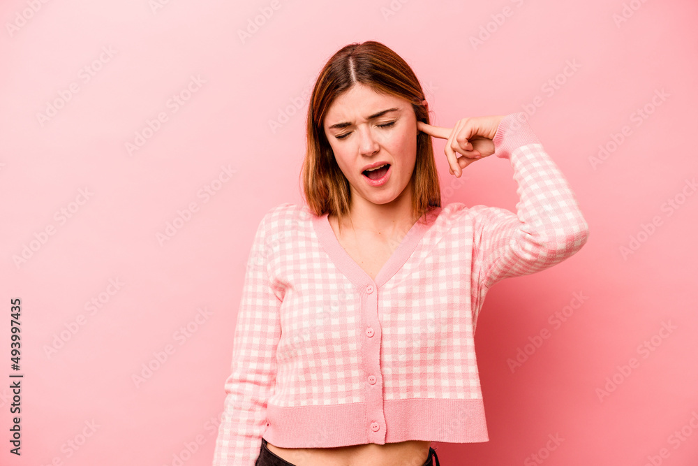 Young caucasian woman isolated on pink background covering ears with hands. Young caucasian woman isolated on pink background covering ears with hands.