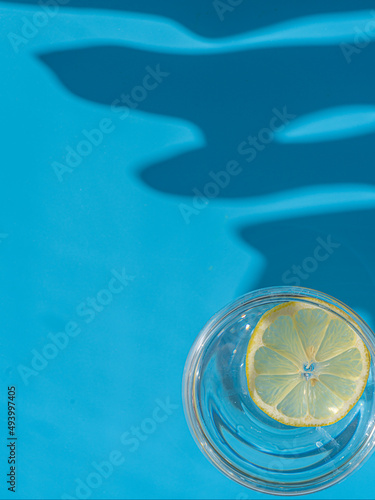 Glass with lemon and lemons on a blue background. The concept of freshness and relaxation © M.V.schiuma