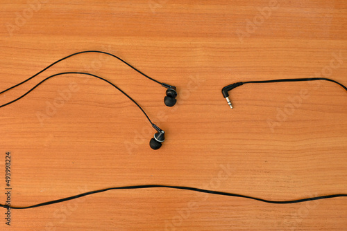 wired headphones tangled in a knot, on a wooden background