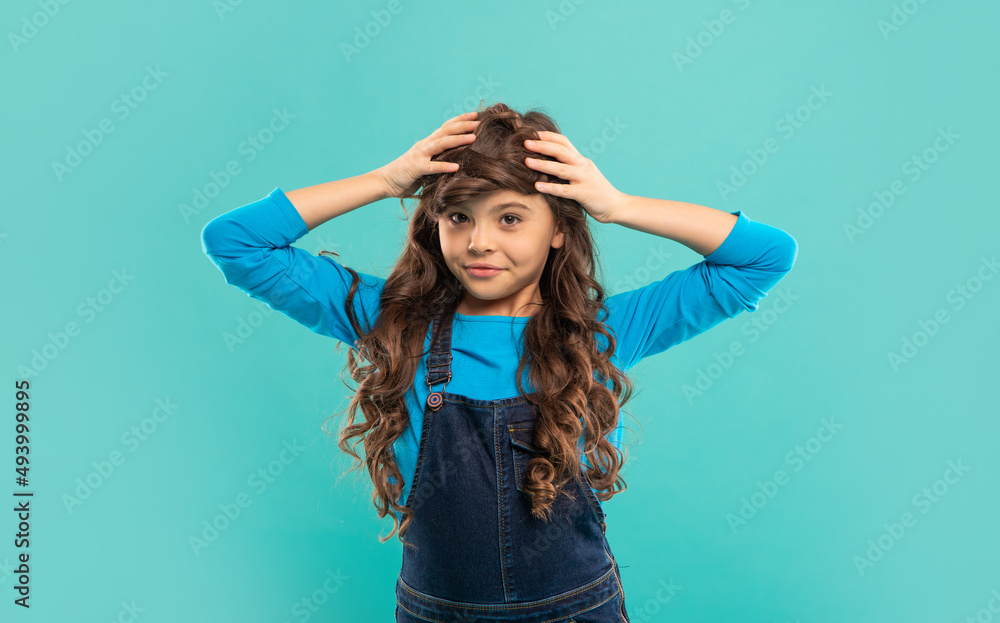 funny child with long curly hair on blue background, haircare