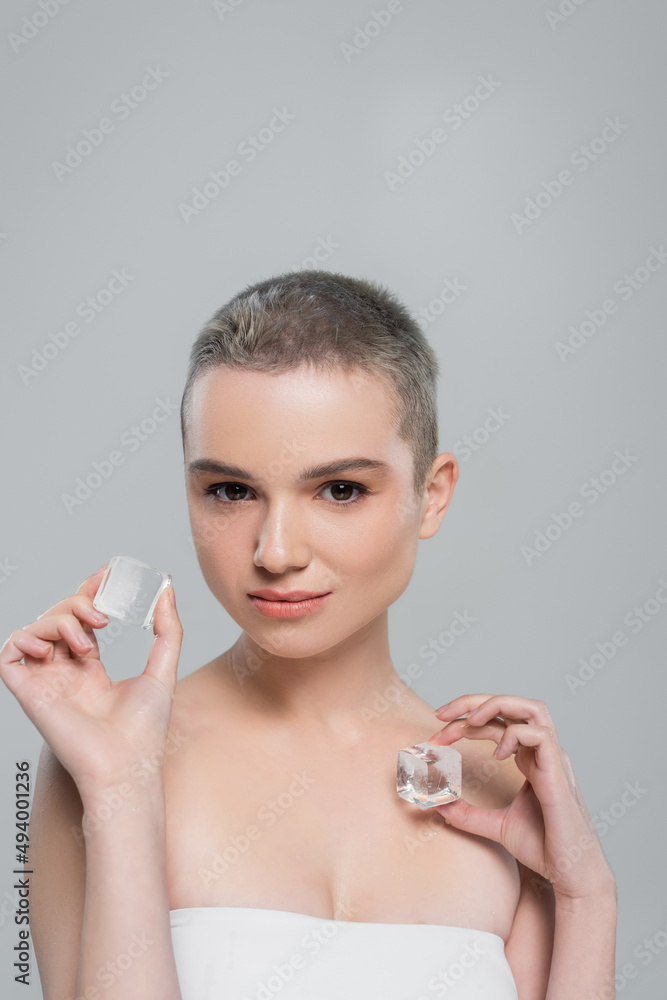 woman with clean skin and natural makeup holding ice cubes isolated on grey. woman with clean skin and natural makeup holding ice cubes isolated on grey.