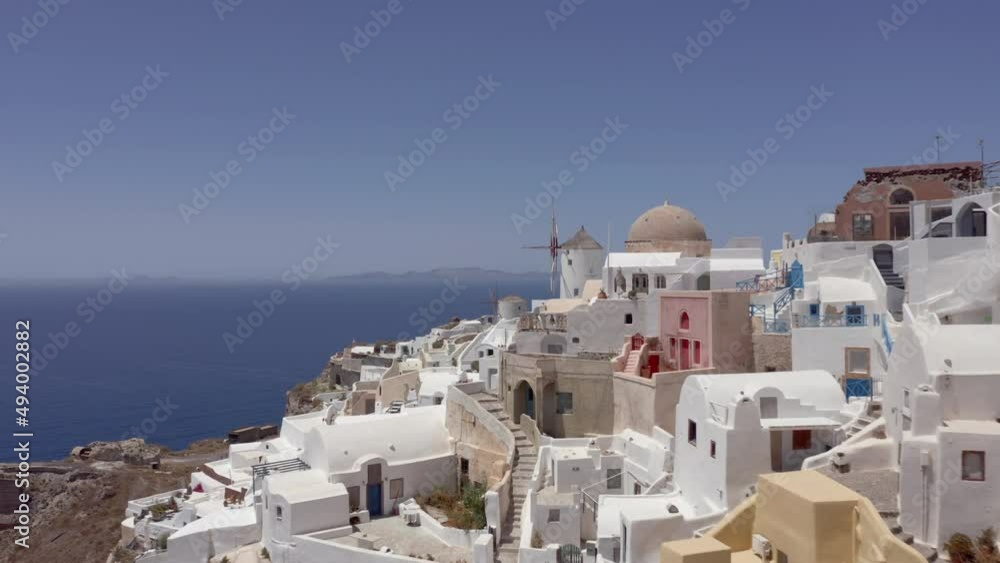Aerial: Drone flies at low altitude in Oia of Santorini, Greece close to the windmills Aerial: Drone flies at low altitude in Oia of Santorini, Greece close to the windmills