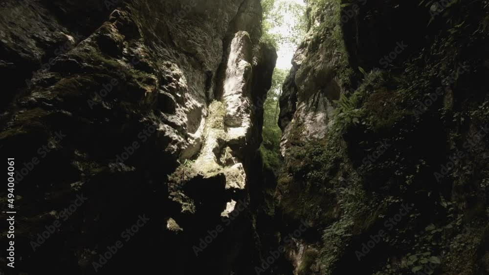 Tilt movement from a sky down to a narrow canyon with a clear and bright torques river. Sun rays are falling down the canyon as the turquoise water flows through. Tilt movement from a sky down to a narrow canyon with a clear and bright torques river. Sun rays are falling down the canyon as the turquoise water flows through.