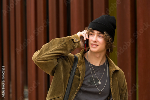 portrait young man with cap and briefcase on the street talking on the phone © luisrojasstock