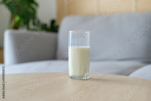 A glass of milk in modern living room with houseplant photo