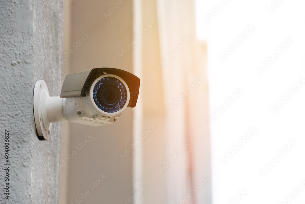 Modern public CCTV camera on wall with blur building background. Recording cameras for monitoring all day and night. Concept of surveillance and monitoring with copy space. Modern public CCTV camera on wall with blur building background. Recording cameras for monitoring all day and night. Concept of surveillance and monitoring with copy space.