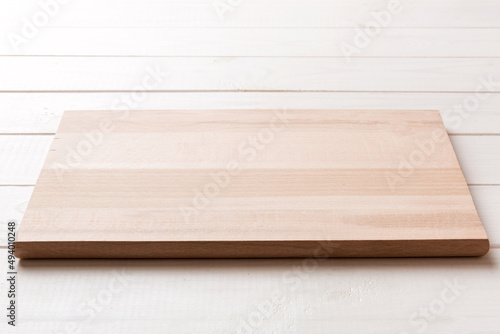 Perspective view of wooden cutting board on wooden background. Empty space for your design