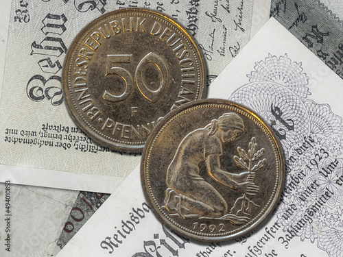 Top view of the front and back of a historic West Germany pfennig coin on a paper background