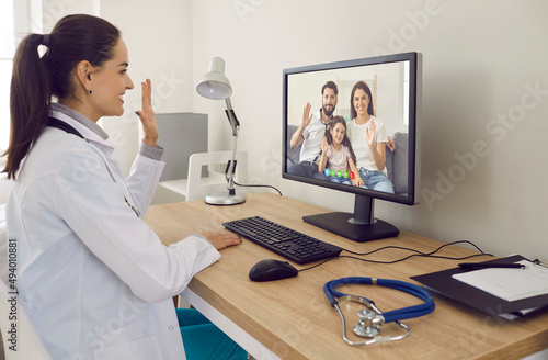 Fényképezés Online family doctor at desk with stethoscope smiling and waving hello at deskto