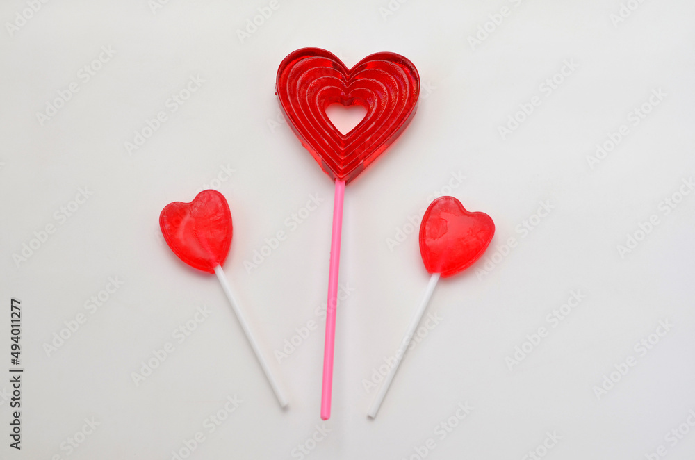 three heart shaped lollipops on white background