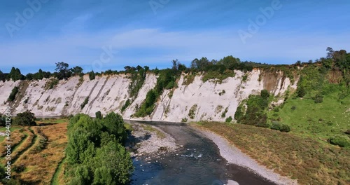 Aerial alongside spectacular clay river cliffs on bright day -Rangitikei NZ photo