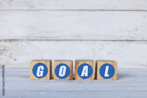 goal concept written on wooden cubes or blocks, on white wooden background.