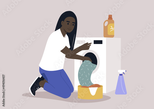 A young female African character loading a washing machine with a pile of laundry, domestic chores