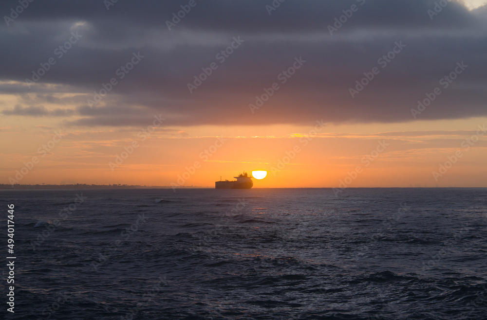 cargo ship at dawn on the horizon of the caribbean sea