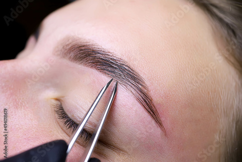 Canvas Print removal of hairs in the eyebrows with tweezers after dyeing and laminating hair