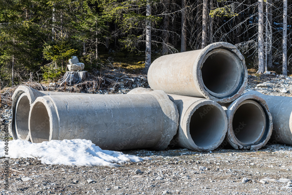 big concrete pipes in the forest with leftover snow big concrete pipes in the forest with leftover snow