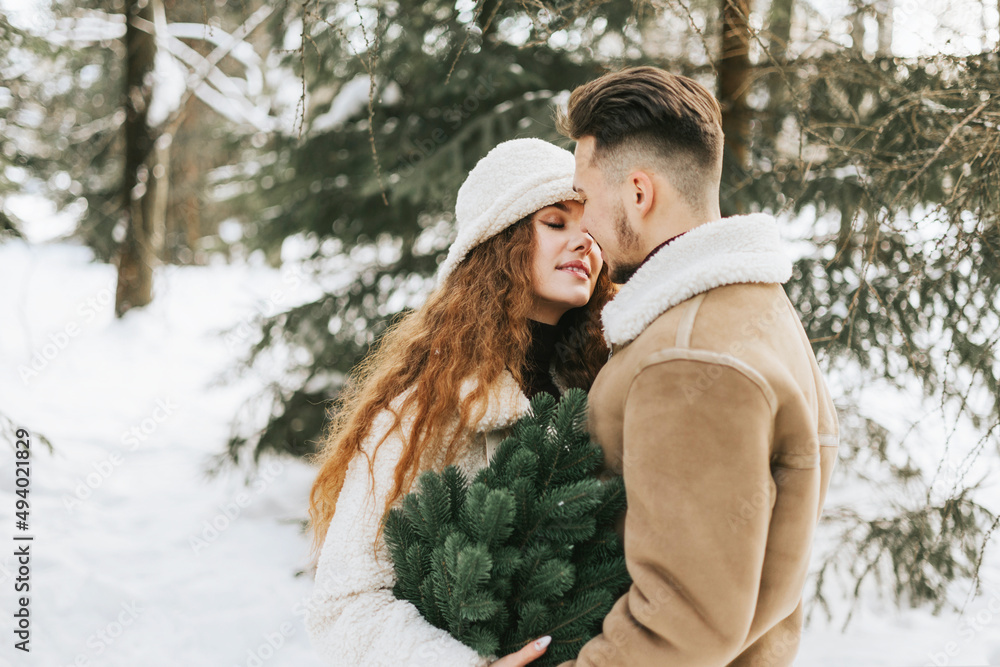 young couple in love man and woman in fashion stylish winter clothes standing in snowy pine forest and having fun spending time together, concept of valentine's day and newlyweds, tenderness and love young couple in love man and woman in fashion stylish winter clothes standing in snowy pine forest and having fun spending time together, concept of valentine's day and newlyweds, tenderness and love